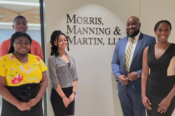 Three high school interns meet with Andrew O. Clarke (second from right), managing partner at District Legal Group, and Shanellah Verna Harris (far right), Morris, Manning & Martin associate.