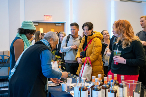 woman mixing drinks while patrons wait on other side of bar