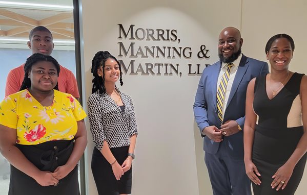 Three high school interns meet with Andrew O. Clarke (second from right), managing partner at District Legal Group, and Shanellah Verna Harris (far right), Morris, Manning & Martin associate.