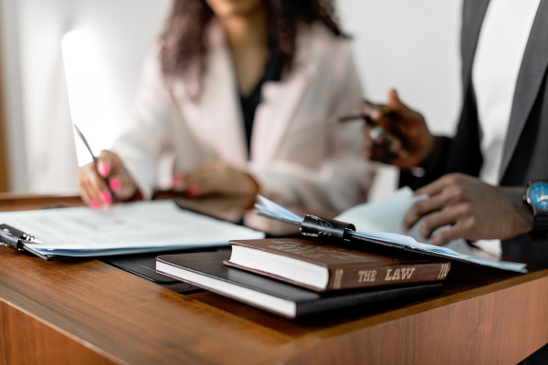 people at desk with law books