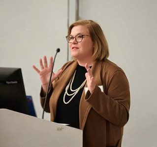 Nancy Drane speaking at podium